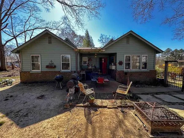 a view of a house with backyard water fountain and sitting area