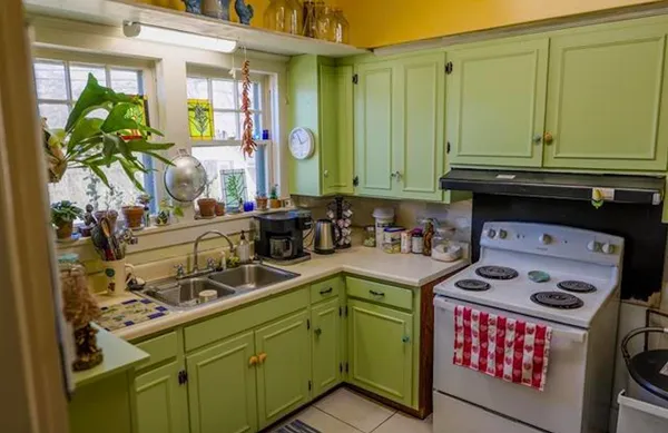 a kitchen with a sink a stove cabinets and a window
