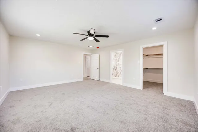 a view of an empty room with a ceiling fan