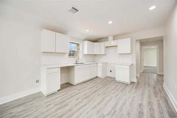 a kitchen with white cabinets and white appliances