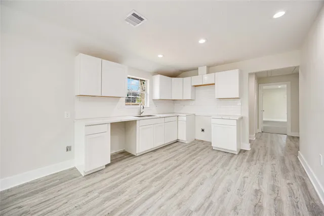 a kitchen with white cabinets and white appliances