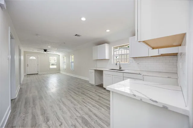 a kitchen with a sink cabinets and wooden floor