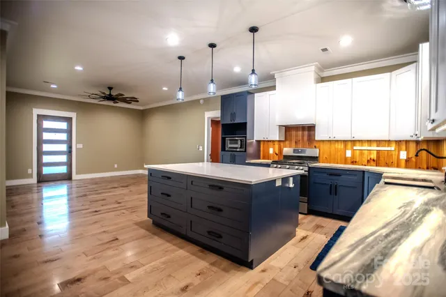 a large kitchen with stainless steel appliances kitchen island granite countertop a refrigerator and a sink