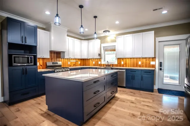 a view of a room with a chandelier and kitchen view