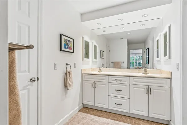 a spacious bathroom with a double vanity sink a mirror and a shower