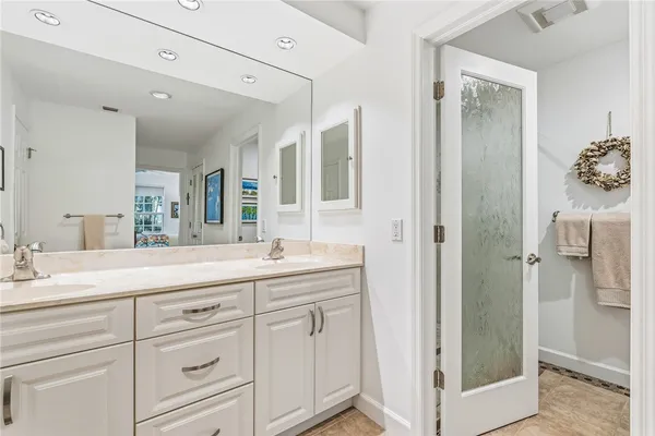 a spacious bathroom with a shower sink and mirror