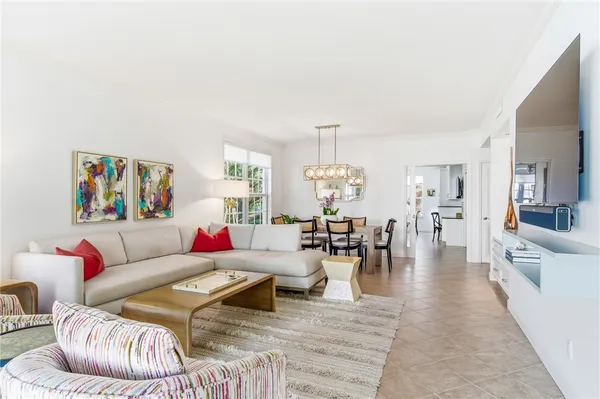 a living room with furniture and a dining table with wooden floor