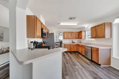 a kitchen with a sink appliances cabinets and a counter top space