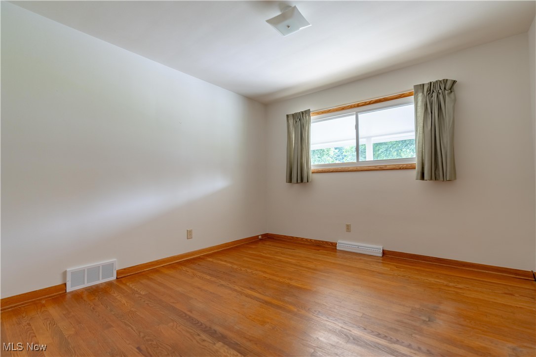 1766 Far View Road Akron, OH 44312 - Photo 20 of 33 Empty room with hardwood floors and baseboards