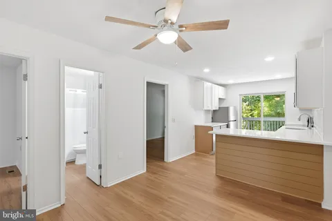 a view of a kitchen with wooden floor and a ceiling fan