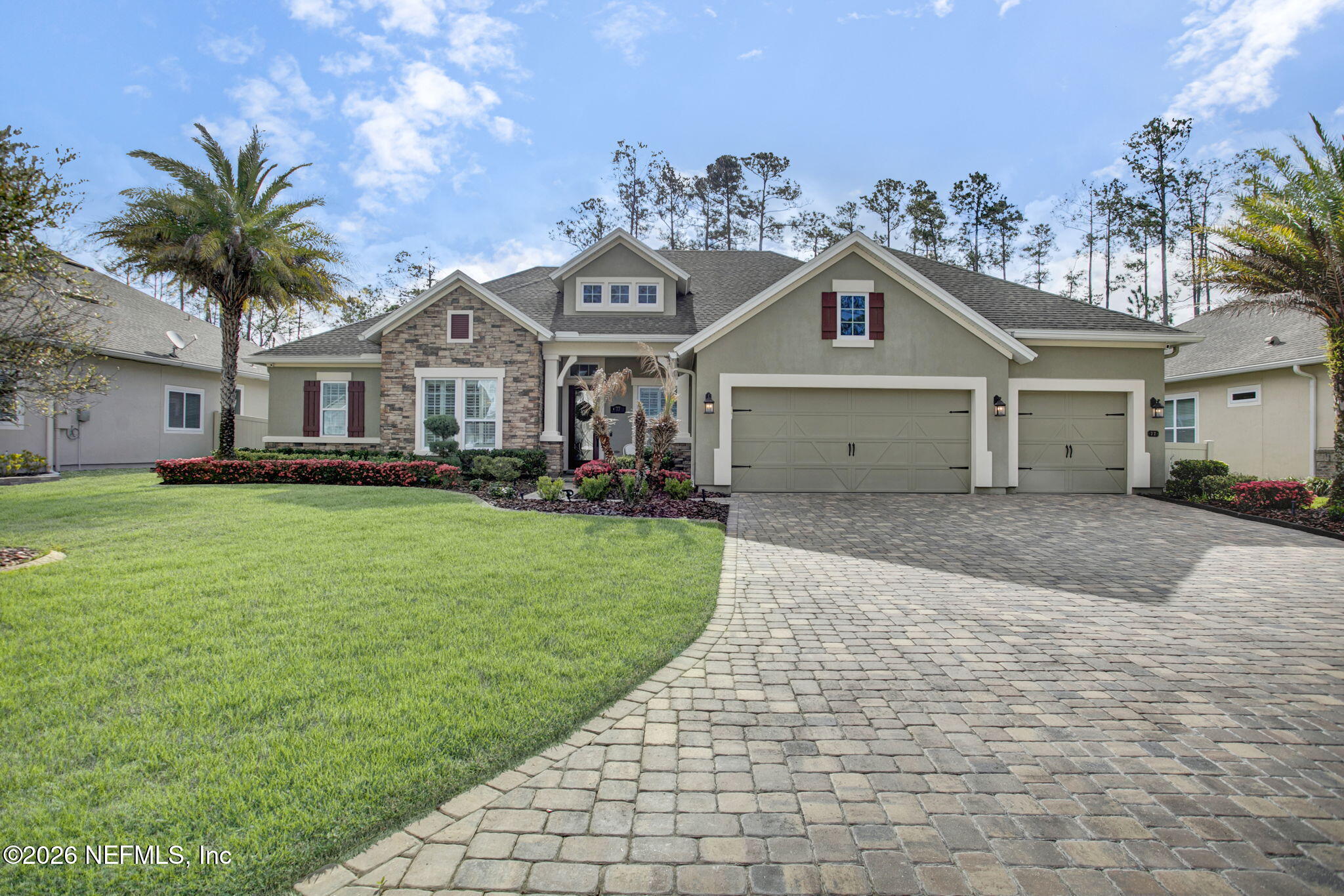 a front view of a house with a garden and trees