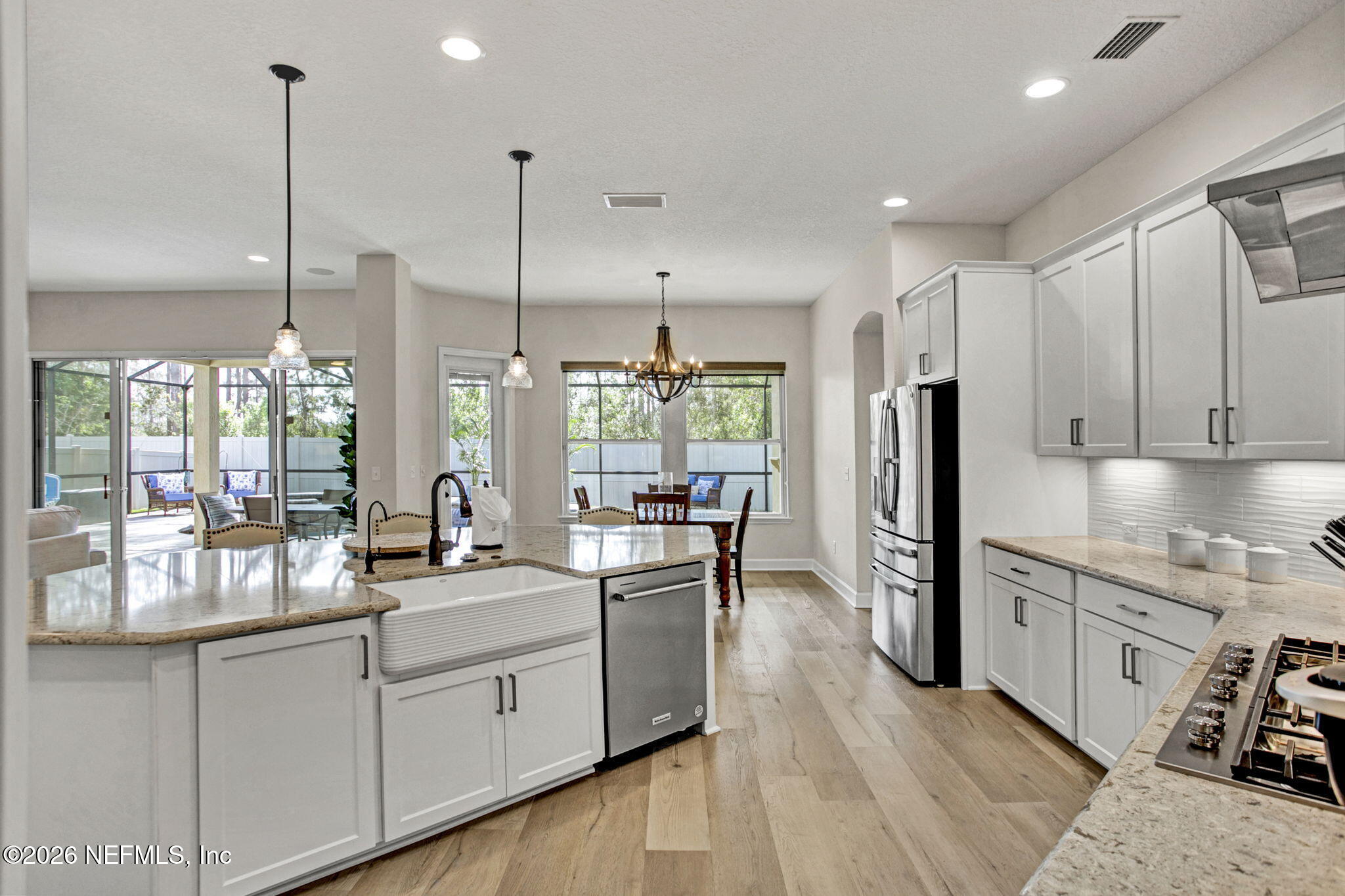 77 Manor Lane St. Johns, FL 32259 - Photo 14 of 41 a kitchen with stainless steel appliances granite countertop a refrigerator a sink dishwasher a stove and white cabinets with wooden floor