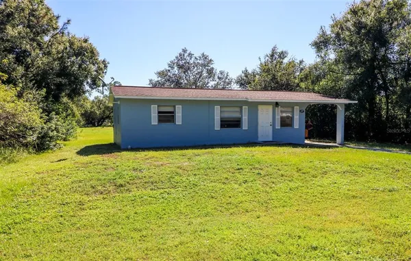 a front view of house with yard and trees around