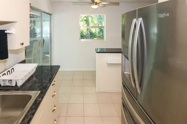 a kitchen with granite countertop a refrigerator and a sink