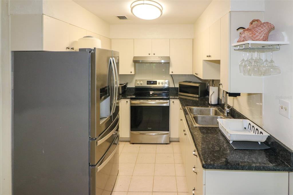 3580 Swanee Road Port Charlotte, FL 33980 - Photo 8 of 22 a kitchen with stainless steel appliances granite countertop a refrigerator a stove and a sink with wooden floor
