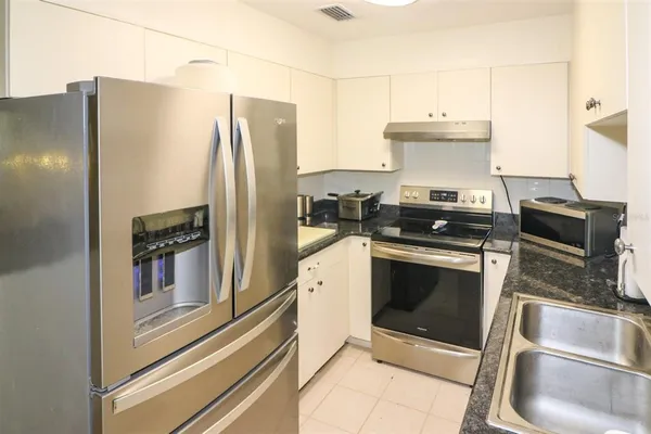 a kitchen with stainless steel appliances granite countertop a refrigerator and a stove