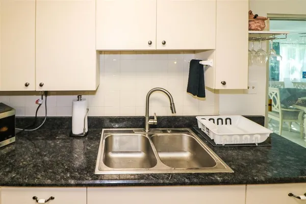 a kitchen sink with granite countertop a sink and a stove