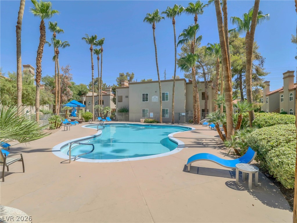 3145 East Flamingo Road, Unit 2129 Las Vegas, NV 89121 - Photo 38 of 43 Swim laps or relax poolside under the palm trees at this vibrant community pool area.