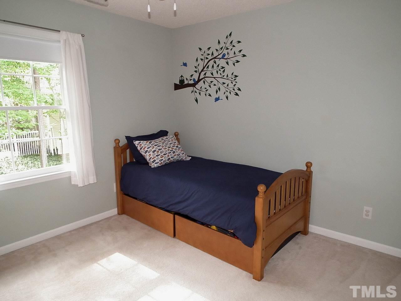 12016 Radner Way Raleigh, NC 27613 - Photo 22 of 25 a blue bed sitting in a bedroom next to a window
