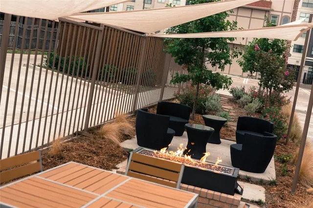a view of a patio with couches chairs potted plants and wooden fence