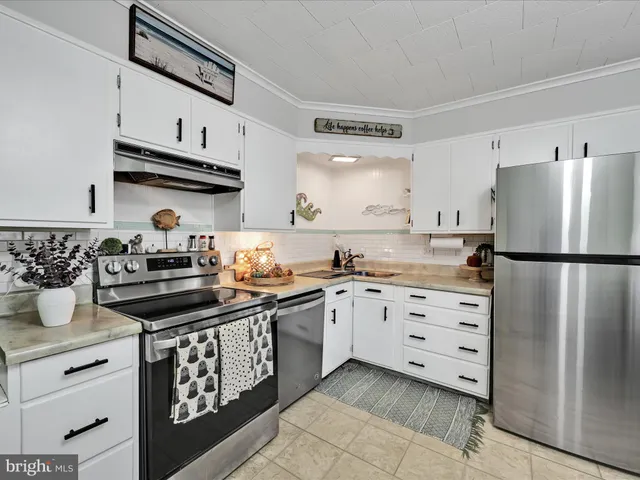 a kitchen with stainless steel appliances granite countertop a stove a refrigerator and a sink
