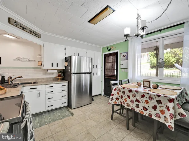 a kitchen with refrigerator cabinets and large window
