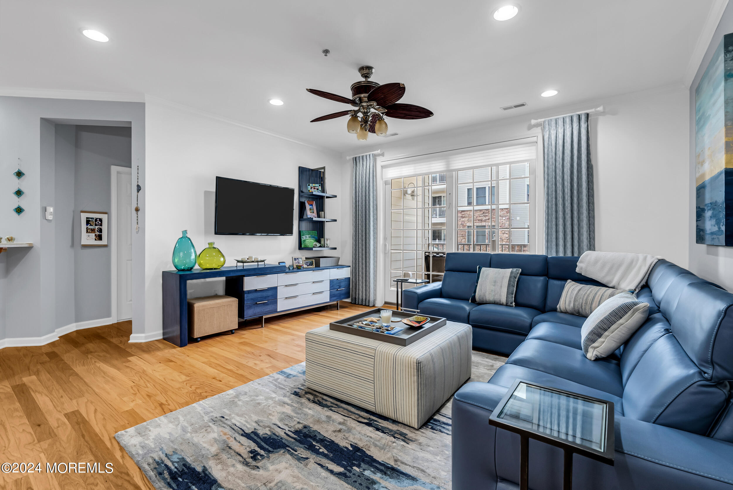 33 Cooper Avenue, Unit 215 Long Branch, NJ 07740 - Photo 16 of 27 a living room with furniture a flat screen tv and a chandelier