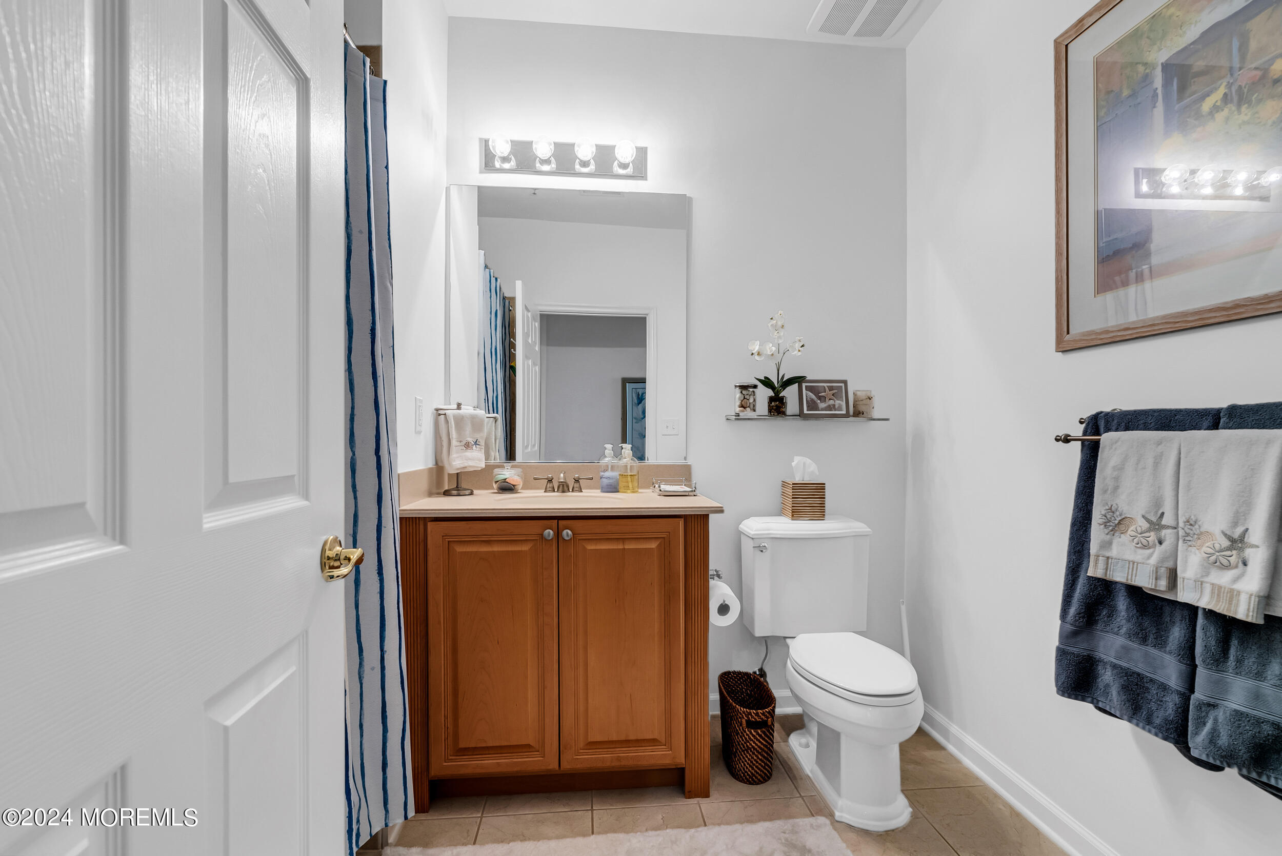 33 Cooper Avenue, Unit 215 Long Branch, NJ 07740 - Photo 25 of 27 a bathroom with a toilet a sink and mirror