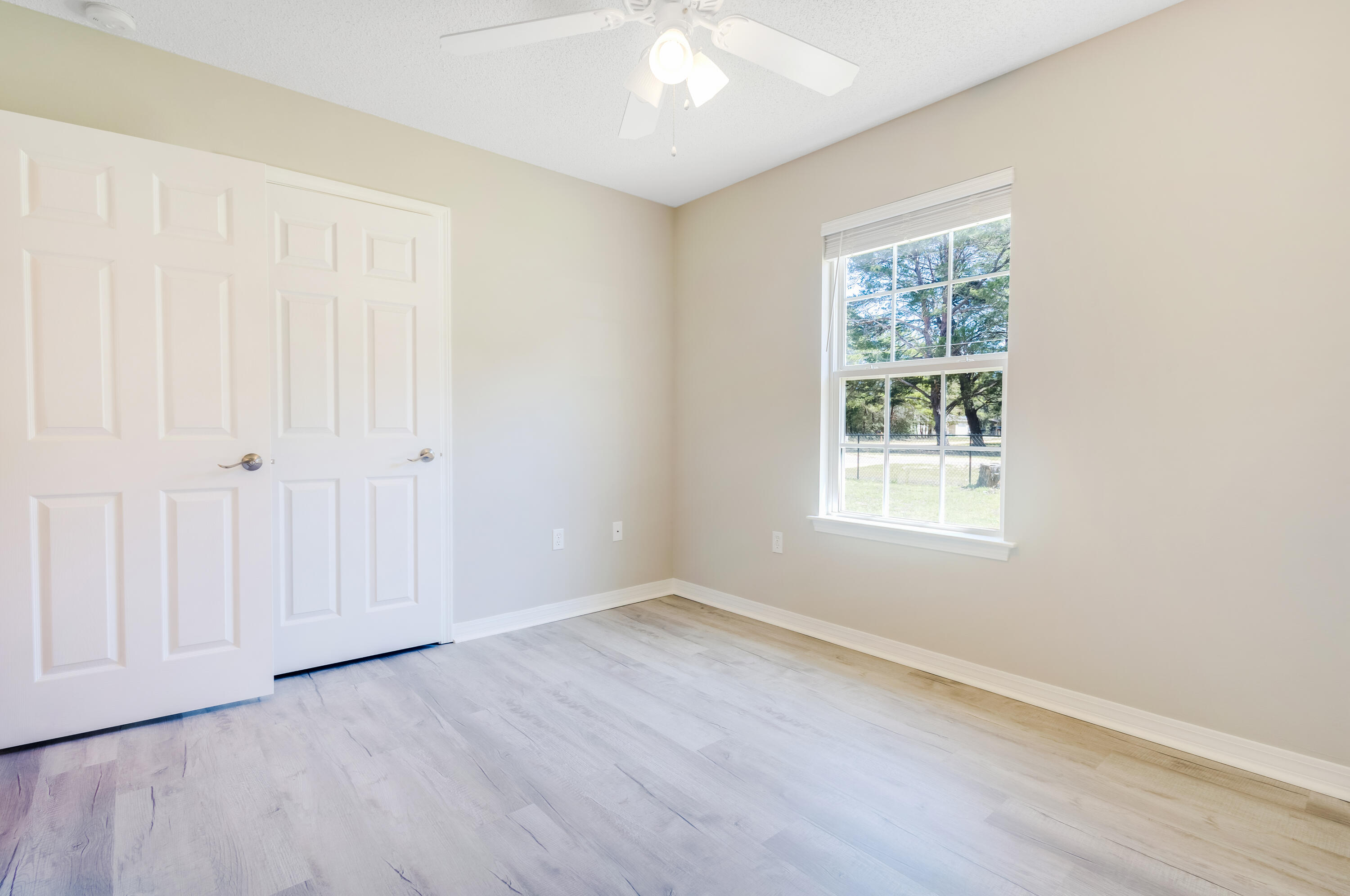 103 Valley View Drive DeFuniak Springs, FL 32433 - Photo 24 of 34 an empty room with wooden floor and windows