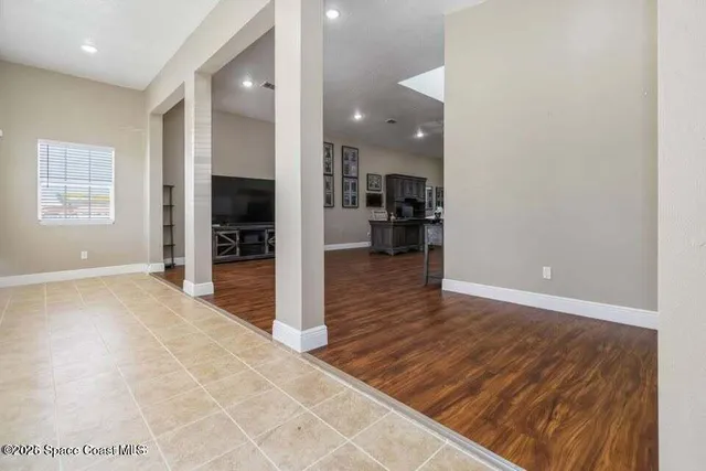 a view of a living room with kitchen island granite countertop wooden floor and a view of living room