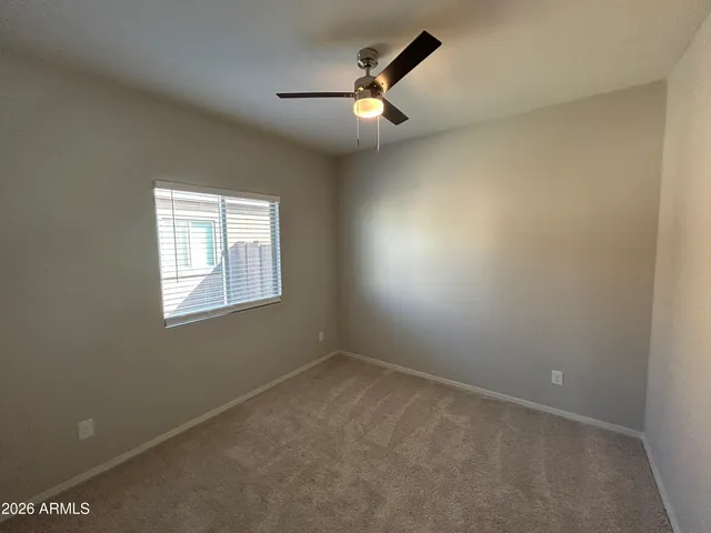 an empty room with a window and a fan