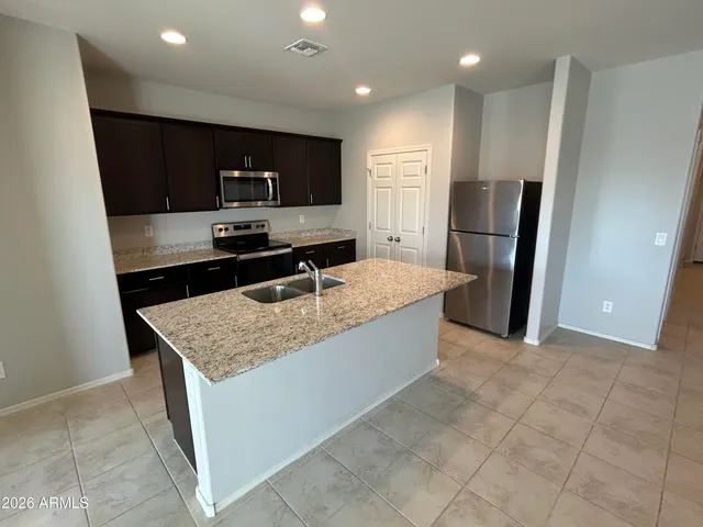 a kitchen with stainless steel appliances granite countertop a sink stove and refrigerator