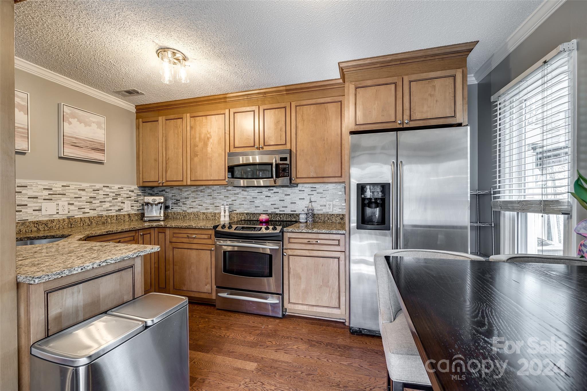 414 West 9th Street, Unit F Charlotte, NC 28202 - Photo 11 of 31 a kitchen with stainless steel appliances granite countertop a stove sink microwave and cabinets