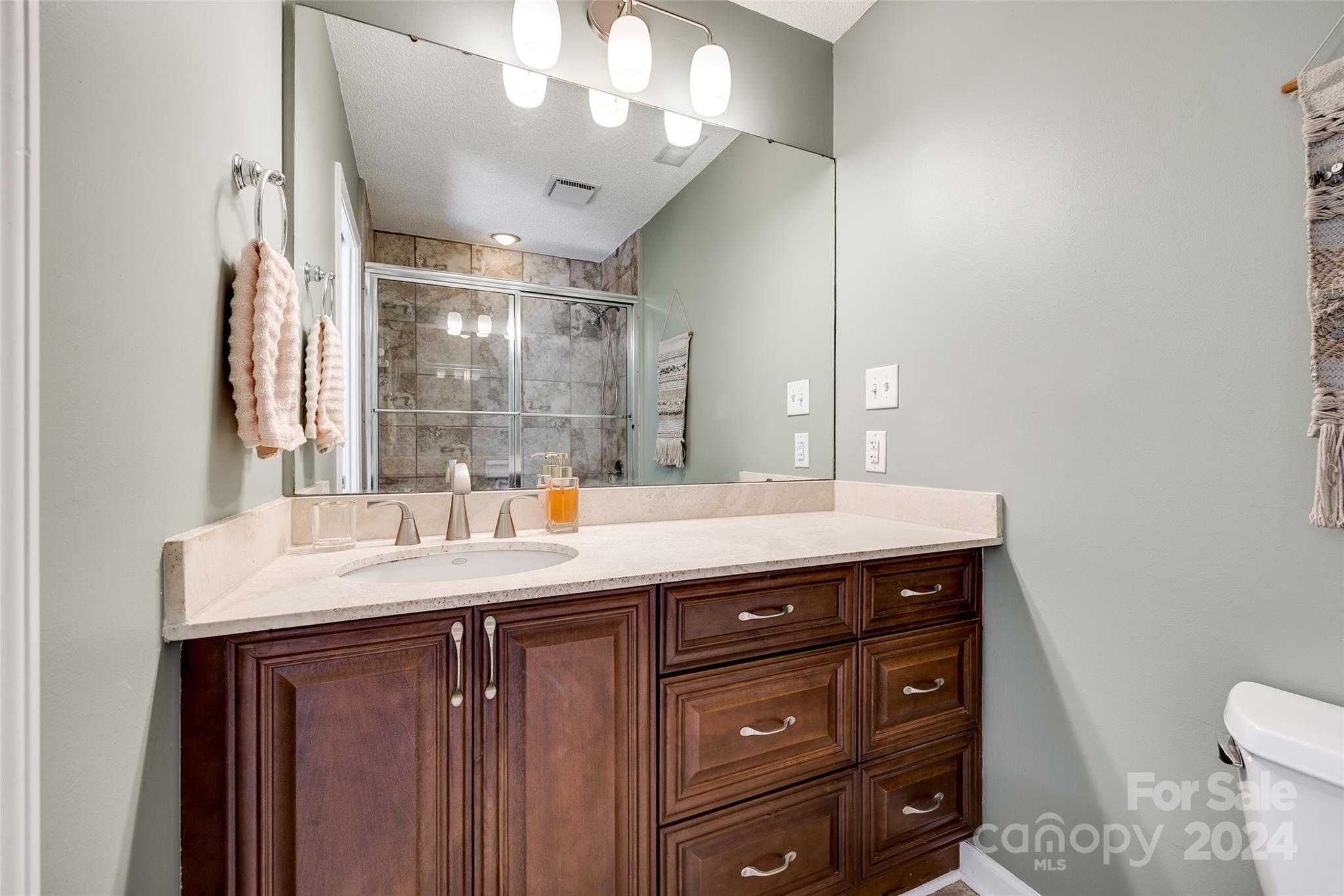 414 West 9th Street, Unit F Charlotte, NC 28202 - Photo 24 of 31 a bathroom with a sink a vanity and a mirror