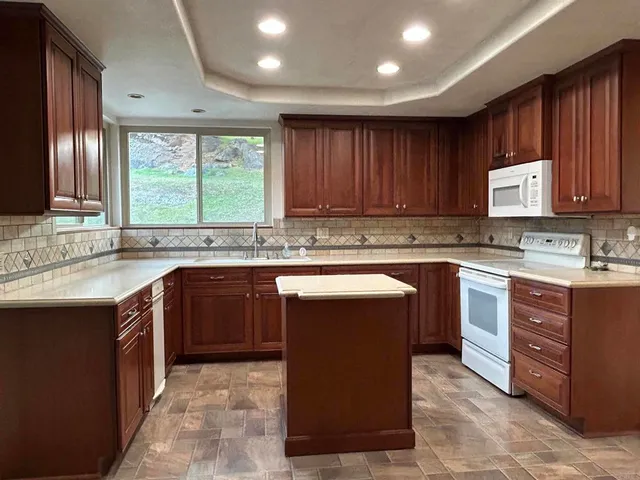 a kitchen with stainless steel appliances granite countertop wooden cabinets a stove top oven a sink and dishwasher