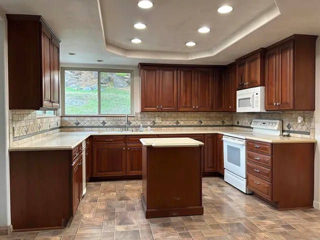 a kitchen with wooden cabinets a sink and a stove