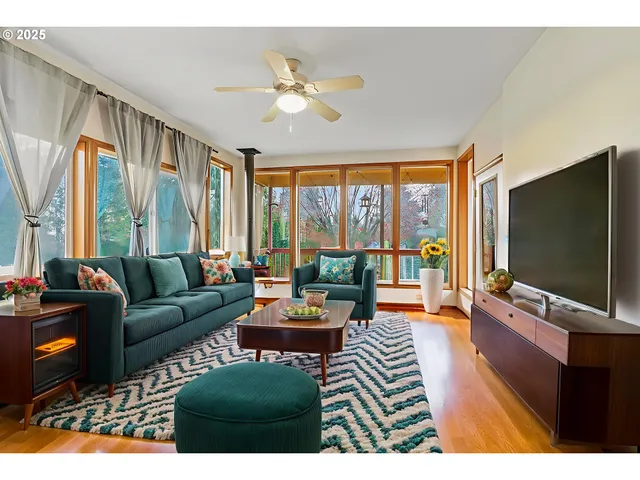 a living room with furniture tv and large windows
