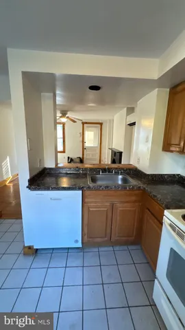 a large kitchen with granite countertop a stove a sink and a microwave