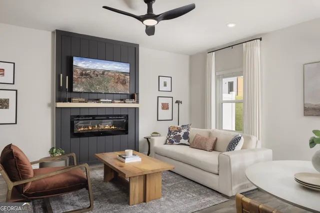 a living room with furniture a flat screen tv and a fireplace