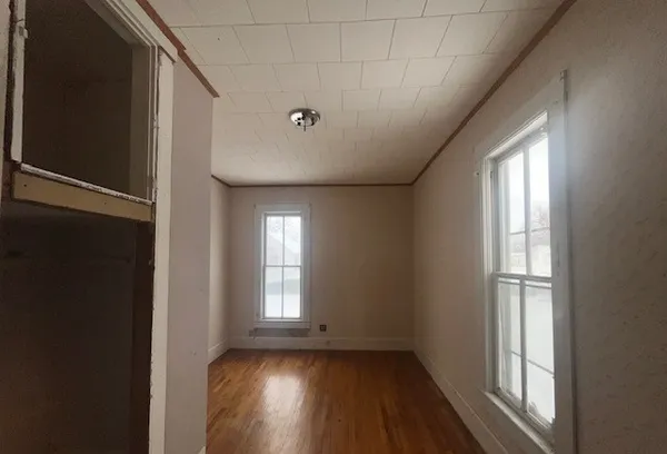 a view of empty room with wooden floor