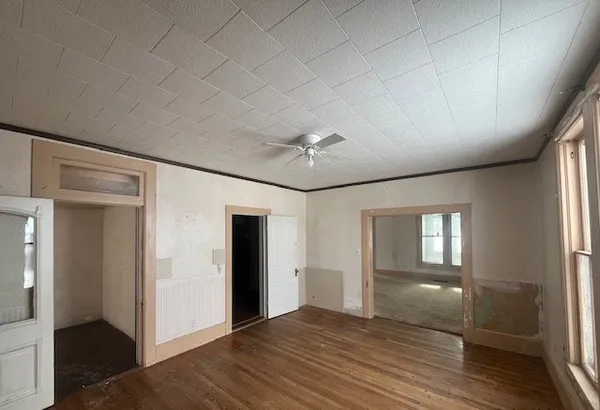 an empty room with wooden floor and windows