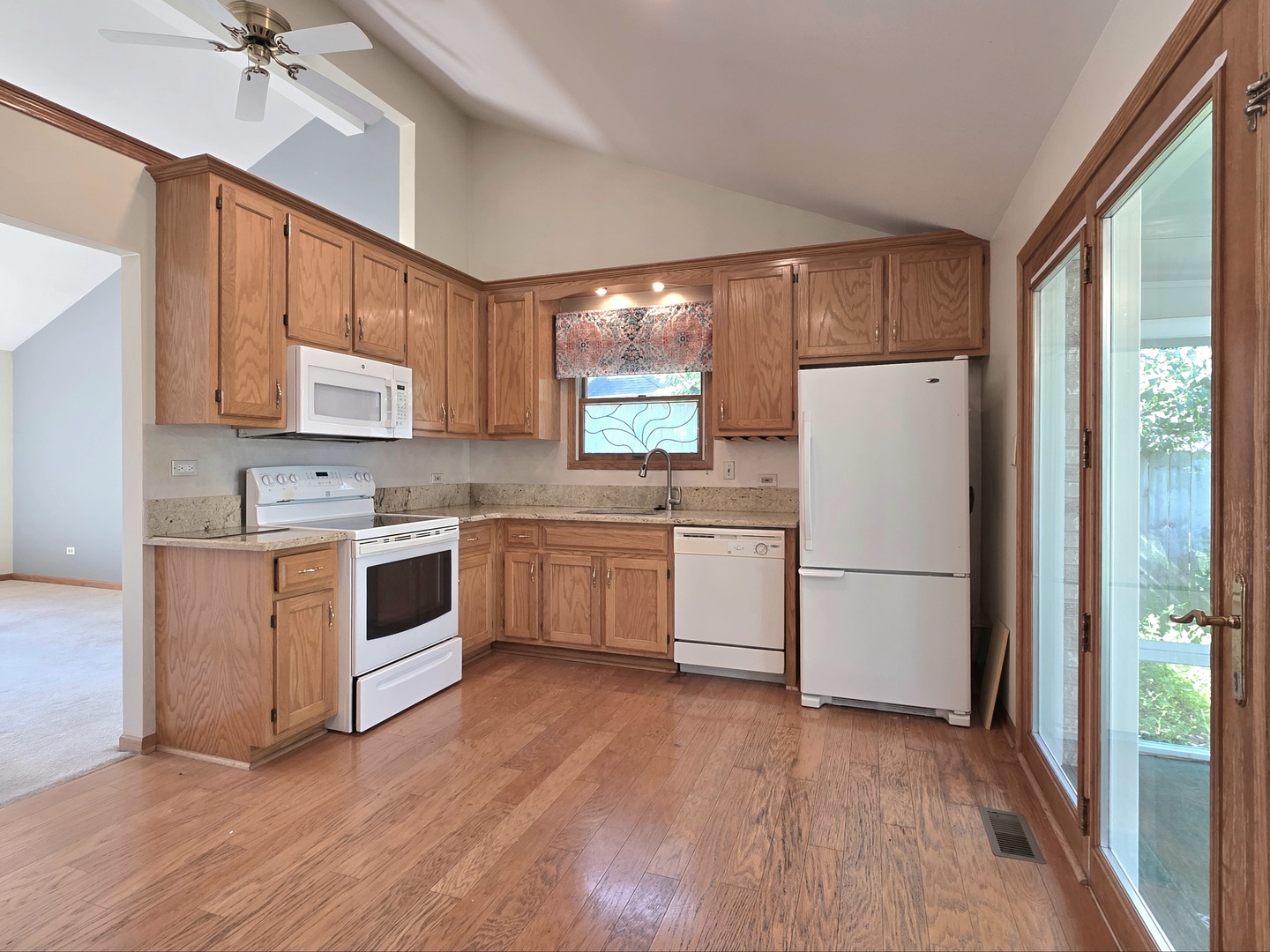 25028 Cashel Bay Road Manhattan, IL 60442 - Photo 5 of 32 a kitchen with a refrigerator wooden floor sink and window