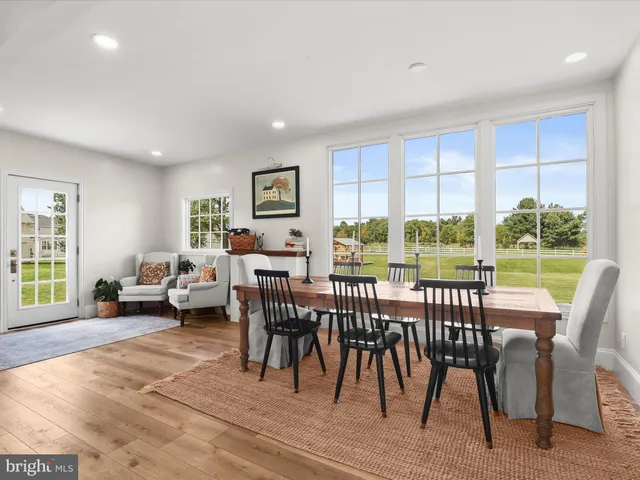 a large room with kitchen island a dining table chairs and a large window