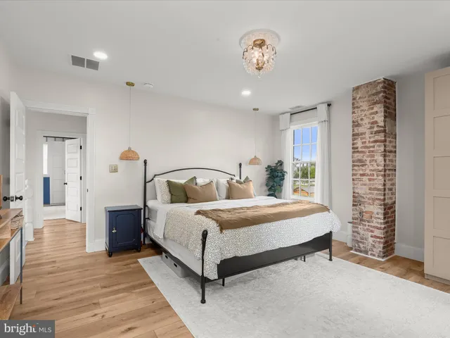 a view of a hallway with wooden floor and furniture