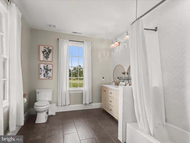 a patio with a table and chairs under an umbrella with large trees