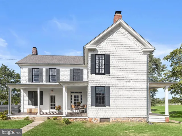 an aerial view of a residential houses with outdoor space and trees