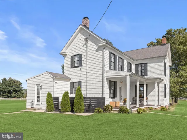 an aerial view of residential houses with outdoor space and trees