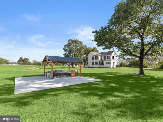 a view of a big house with a big yard and large trees