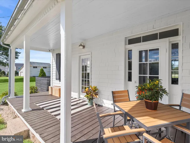 a view of a patio with table and chairs potted plants with wooden floor