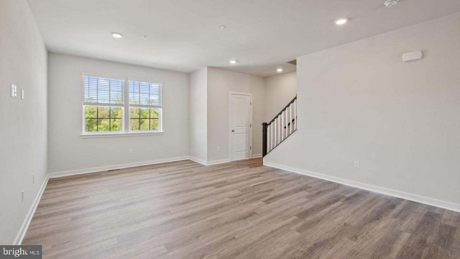 7521 Silver Thread Way Brandywine, MD 20613 - Photo 9 of 39 a view of an empty room with wooden floor and a window